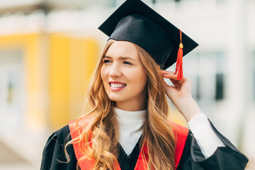 Happy beautiful girl student, in a master's dress