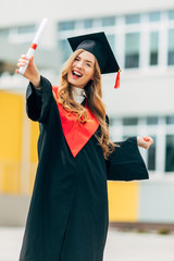 Happy beautiful student with a graduation diploma