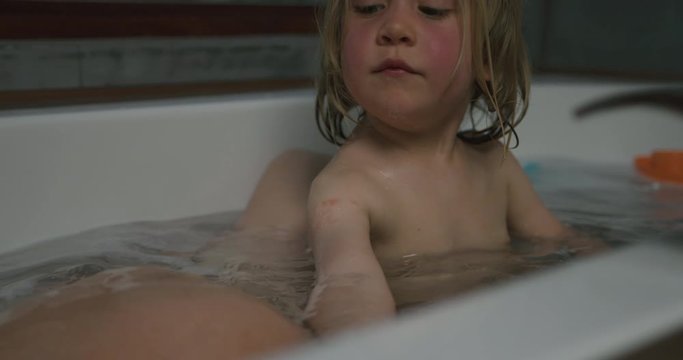 Preschooler boy in bathtub with his pregnant mother