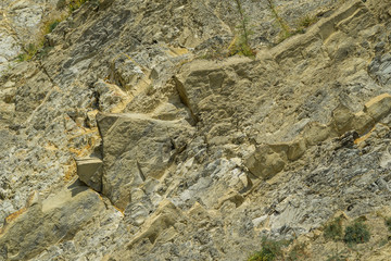 Striped natural texture of stones and rock fragments on Caucasus mountains on Black Sea coast in Olginka as original texture background. Brown, yellow, gray colored stone. Nature concept for design