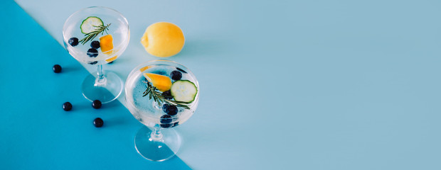 Banner with two glasses of Gin and Tonic isolated on blue background