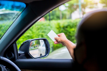 Selective focus to driver hold card to scan at card reader station for open the car park door.