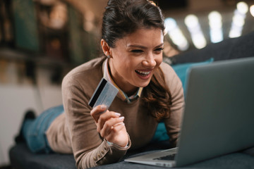 Obraz premium Young woman paying online. Beautiful businesswoman using e-banking 