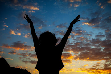 A woman in silhouette watches the sky of a beautiful sunset in the city of Rio de Janeiro.