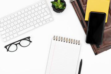 flatlay White office desk table. keyboard, glasses, smartphone, notebook and laptop case. copy space layout