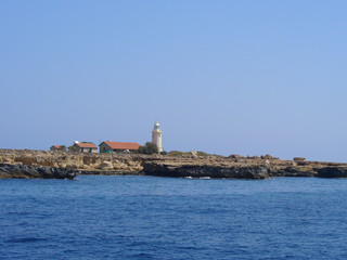 The white lighthouse stands near the sea