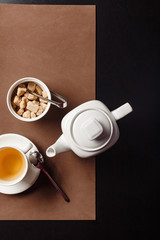 Traditional green tea in a white fancy tea pot with brown sugar on the table top view photography. Best use for restaurant magazine or book menu concept.