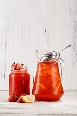 Traditional Homemade lemonade refreshment in a jar and glass flavored with orange, strawberry and lemon. Picture best use for Mexican restaurant book menu concept.