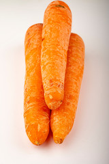a few ripe carrots on a white background. Close up.