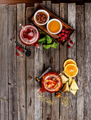 Authentic tea with dried fruit in sweetened syrup. Raspberry and pineapple tea table nice presentation with white sugar cubes on a wooden table photography best use for magazine.