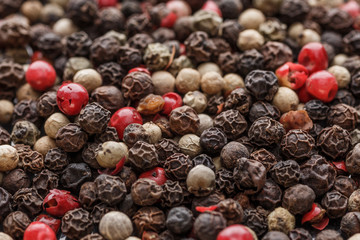 Close up of Mixted multi coloured peppercorns. white, black and green peppercorns macro background.Mixed peppercorns red black and white in bowl - Close-up.