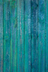 Fototapeta na wymiar Backgrounds and texture concept. Pastel old vertical wooden fence painted in dark green and blue rugged paint in grunge style