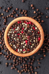 A set of peppers.Collage of different type pepper, Black ,white, pink and allspice peppercornsr, dried chili pepper.Top view. On a black background. free space for your text.