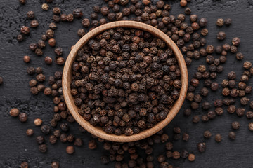 Peppercorn background. Dry black pepper seeds. Top view.On a black background. free space for your text.