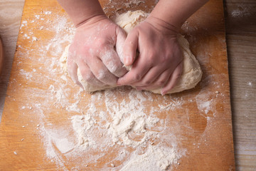 Female hands mixing dough in the home kitchen.
