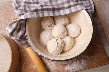 Balls of dough are in a large yellow bowl. Cooking at home.