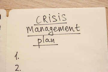 crisis management plan written words in notebook