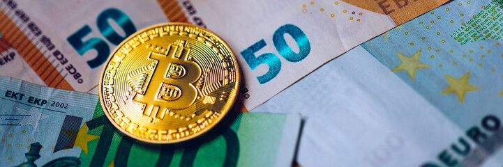 Fototapeta na wymiar Golden bitcoin over Euro money. Bitcoin cryptocurrency. Crypto currency concept. Bitcoin with euro bills. Bitcoins stacked on euro banknotes.
