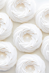 Obraz na płótnie Canvas A macro top down view of several bright white meringues.