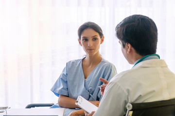 Doctor man wear uniform with pen and stethoscope sitting in office while talking about problem health patient woman fell friendly. Patient young woman listen advice doctor. Health-care concept.