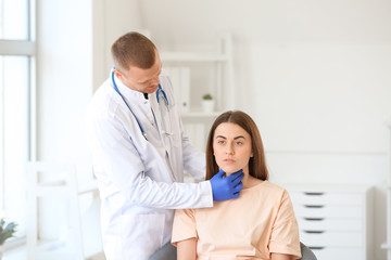 Fototapeta premium Endocrinologist examining throat of young woman in clinic