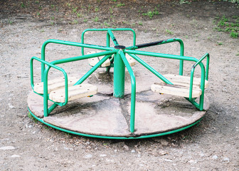 Round green swing in the playground on street