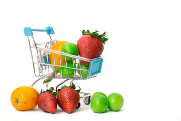 shopping cart and various fruits. plum, loquat and strawberry on white background
