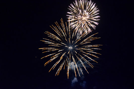 Festive salute in night sky. Explosions of fireworks and pyrotechnics in the sky.