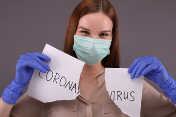 Young woman tears sign "coronavirus"