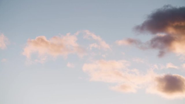 Dramatic blue sky with pink fluffy clouds turning orange then darker. Gathering dark clouds of apocalypse. Slow motion b roll. Timelapse cloudscape. Beautiful concept of brighter days ahead