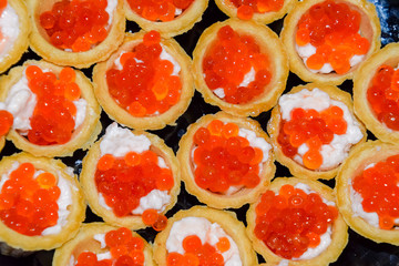 Waffle cups with mayonnaise and red caviar.