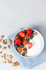 Homemade oatmeal granola bowl with greek yogurt, berries, honey and nut
