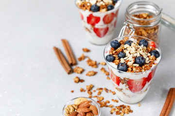 Granola parfait with greek yogurt, oat cereal, fresh berries, honey in glass jar