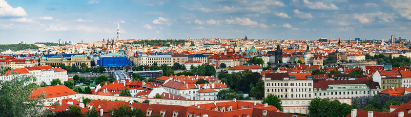 Naklejka na ściany i meble Aerial panoramic cityscape view with old Red Tiles roofs and St Nicholas Cathedral in Old town of Prague city, Czech Republic, Europe. Beautiful summer day, blue sky with clouds at sunset