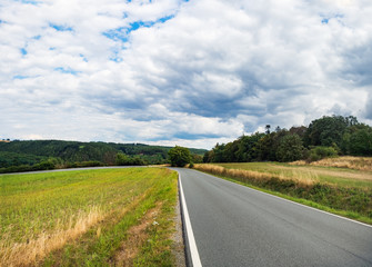 Fototapeta na wymiar Open Road in future, no cars, auto on asphalt road through green forest, trees, agricultural fields. Green countryside landscape in summer day, Czech Republic, Europe