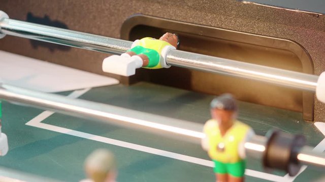 Close up of table soccer game miniatur football yellow brasil player miss the ball and gets goal shot in 4k super slow motion