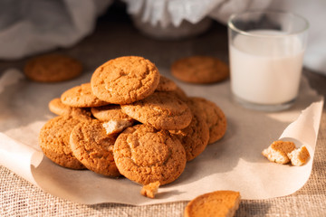 Healthy oatmeal cookies with a glass of milk kids breakfast on burlap fabric background. Homemade food. Eat at home concept