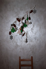 Christmas composition on dry branch in front of a metallized wall
