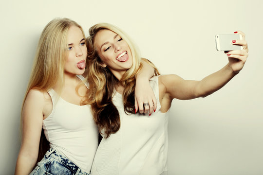 Two Young Women Taking Selfie With Mobile Phone