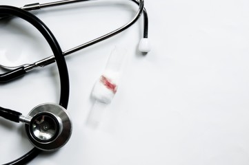 Blood on cotton wool and white plaster on white background with Stethoscope. Blood Donation Morphology vaccines concept.