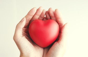 Obraz premium Woman hand holding red heart, health care, donate and family insurance concept, world heart day, world health day,CSR responsibility, adoption foster family, hope, gratitude, kind, concept