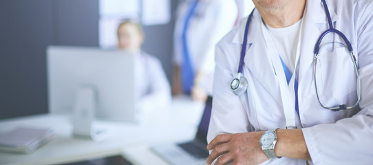 Portrait of a smiling doctor in his bright office
