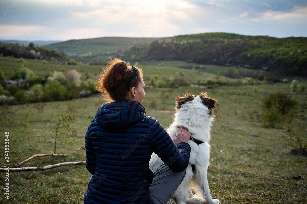 Wall mural woman and dog enjoying outdoors on a green field