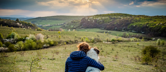 woman and dog enjoying outdoors on a green field