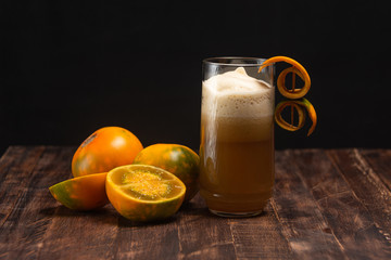 Organic lulo or naranjilla south america exotic fruit. Slice and whole fruits and juice glass on...