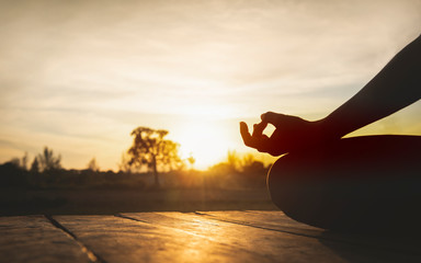 Close up hands. Woman do yoga relax outdoor. Woman exercising pose vital and meditation for fitness lifestyle at the outdoors nature background. Healthy and Yoga Concept.