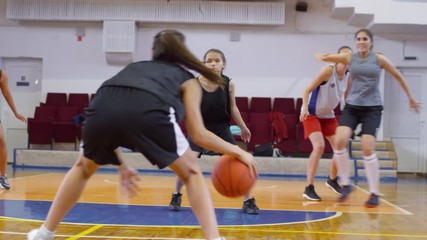 Young multiethnic female athletes in sportswear playing basketball on indoor court - Powered by Adobe