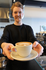 Barista serving coffee in a cafe