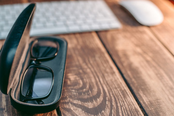 Glasses for sight and vision correction and protection from computer with ptotection case on the wooden table