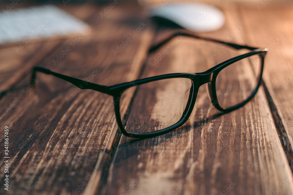 Wall mural Glasses for sight and vision correction and protection from computer on the wooden table